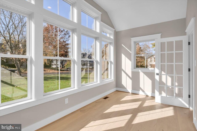 unfurnished sunroom featuring vaulted ceiling