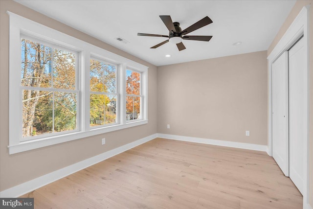 unfurnished bedroom featuring a closet, light hardwood / wood-style flooring, and ceiling fan