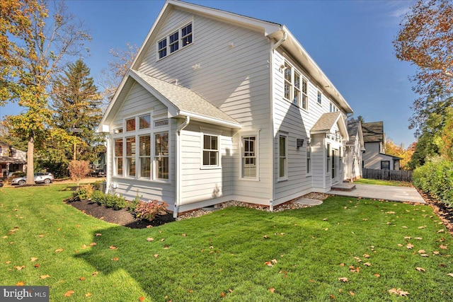 rear view of house featuring a yard and a patio