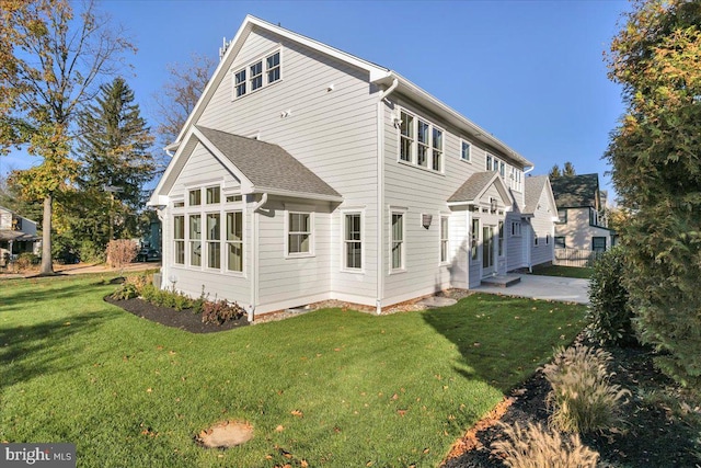 rear view of property with a yard and a patio area