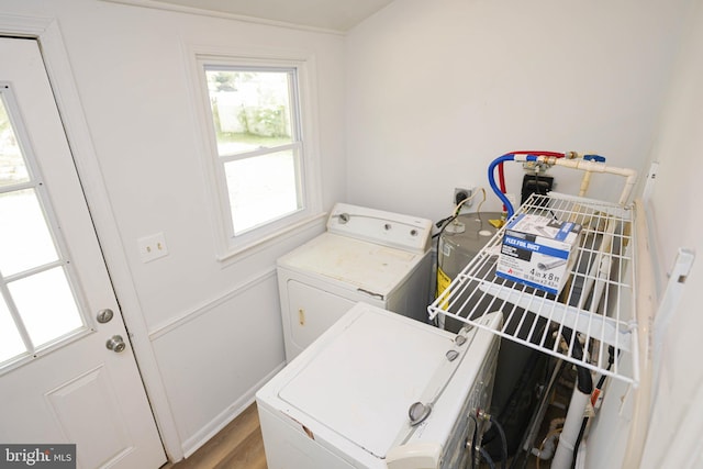 clothes washing area with independent washer and dryer and light hardwood / wood-style flooring