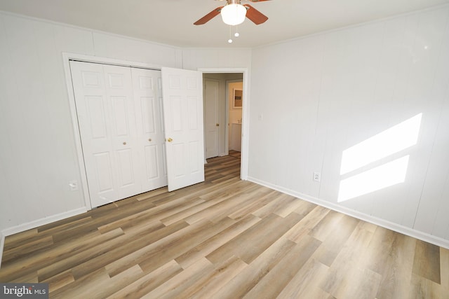 unfurnished bedroom featuring ornamental molding, a closet, hardwood / wood-style flooring, and ceiling fan