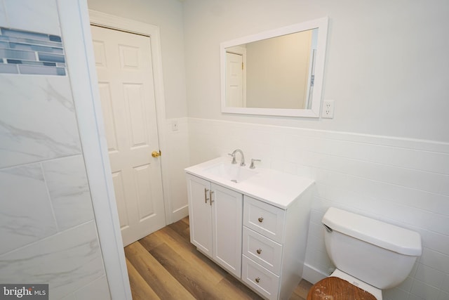 bathroom featuring toilet, vanity, tile walls, and hardwood / wood-style flooring