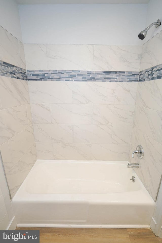 bathroom featuring tiled shower / bath combo and wood-type flooring