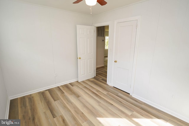 unfurnished room featuring light wood-type flooring, ceiling fan, and crown molding