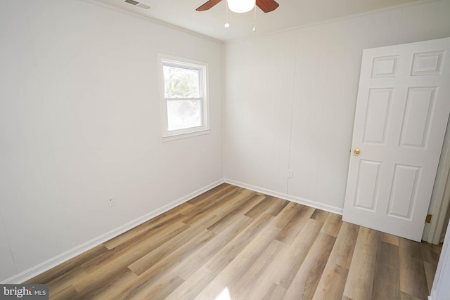 empty room featuring ornamental molding, light wood-type flooring, and ceiling fan