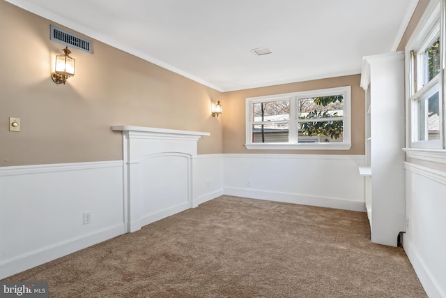 empty room with light carpet, ornamental molding, and a healthy amount of sunlight