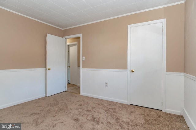 unfurnished bedroom with crown molding and light colored carpet