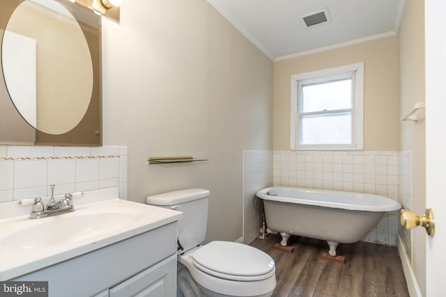 bathroom featuring toilet, crown molding, wood-type flooring, vanity, and a bathing tub