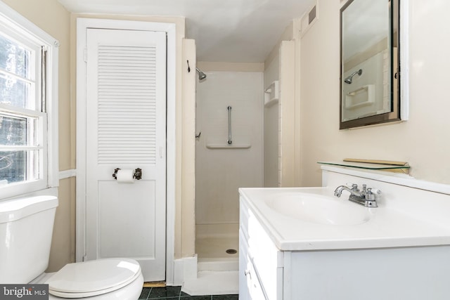 bathroom featuring tile patterned floors, vanity, toilet, and a shower