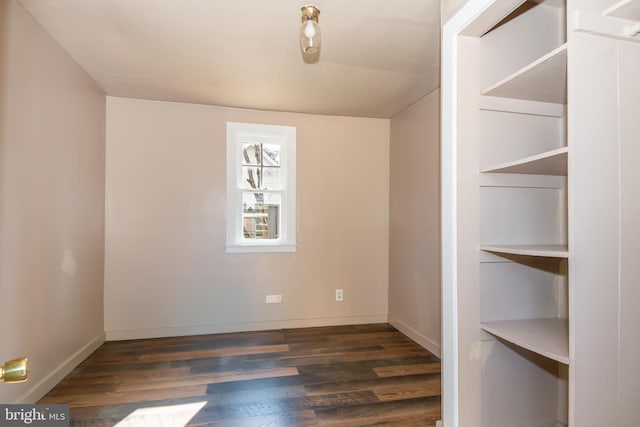 unfurnished room with dark wood-type flooring