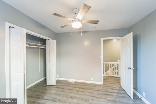 unfurnished bedroom with light hardwood / wood-style floors, a closet, and ceiling fan