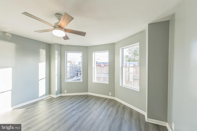 empty room with ceiling fan and light hardwood / wood-style flooring