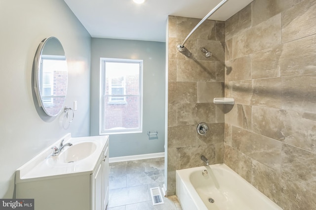 bathroom featuring vanity, tiled shower / bath combo, and tile patterned flooring