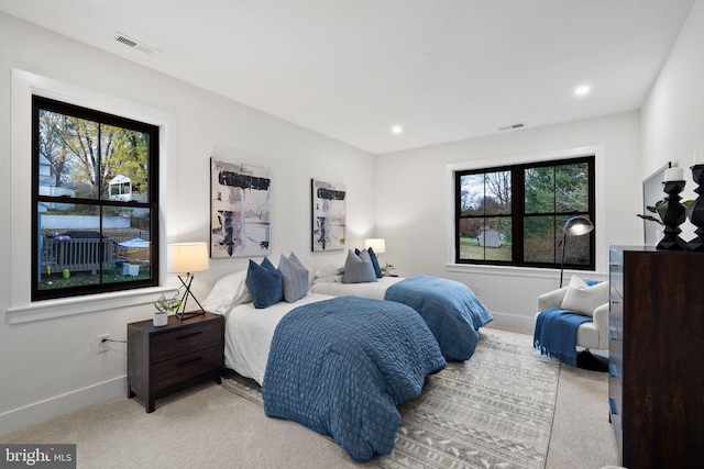 bedroom with light carpet and multiple windows