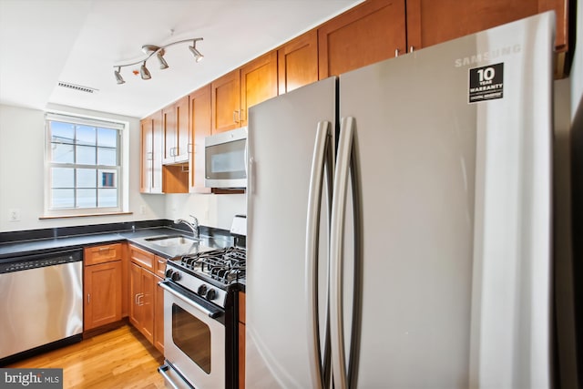 kitchen with light hardwood / wood-style flooring, sink, and stainless steel appliances