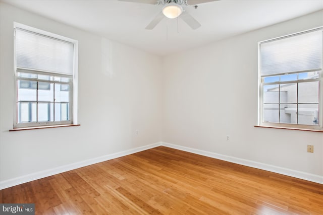 unfurnished room featuring hardwood / wood-style flooring, a healthy amount of sunlight, and ceiling fan