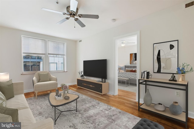 living room featuring hardwood / wood-style floors and ceiling fan