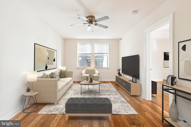 living room with ceiling fan and light hardwood / wood-style flooring