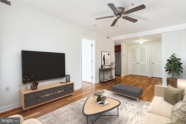 living room featuring hardwood / wood-style floors and ceiling fan