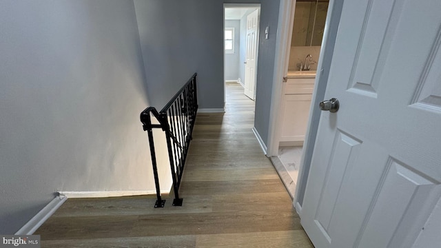 hallway with sink and light hardwood / wood-style flooring