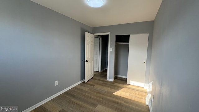 unfurnished bedroom with a closet and dark hardwood / wood-style flooring