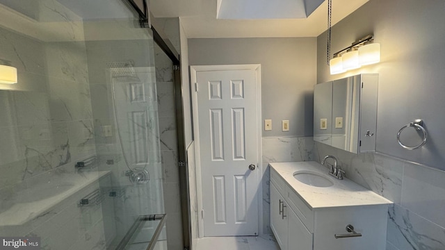 bathroom with tile walls, vanity, and an enclosed shower