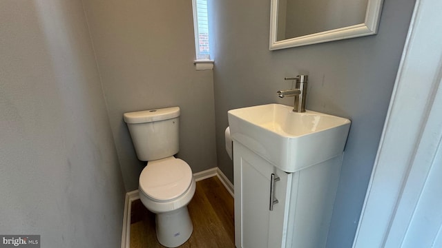 bathroom featuring wood-type flooring, vanity, and toilet