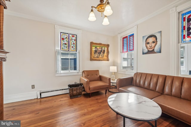 living room with a baseboard radiator, hardwood / wood-style flooring, ornamental molding, and a notable chandelier