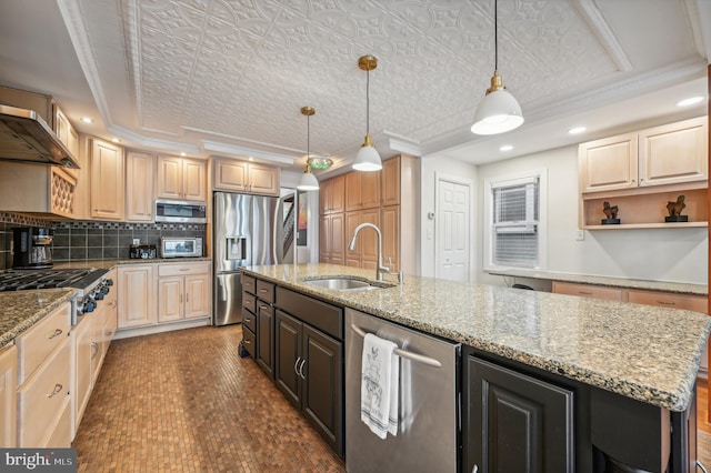 kitchen featuring light stone countertops, sink, stainless steel appliances, pendant lighting, and a kitchen island with sink