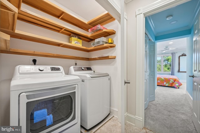 laundry area featuring ceiling fan, washer and clothes dryer, light colored carpet, and ornamental molding