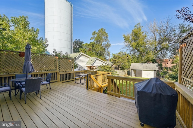 wooden terrace with a storage shed and grilling area