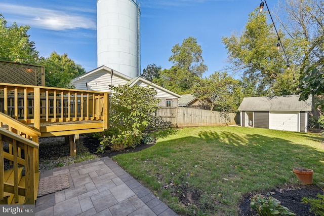 view of yard with a garage, an outdoor structure, and a wooden deck