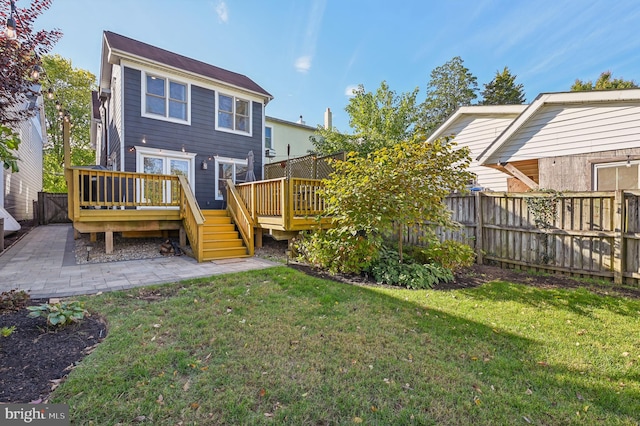 rear view of house featuring a yard and a deck