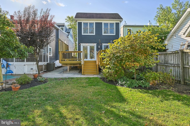 back of property with a lawn and a deck