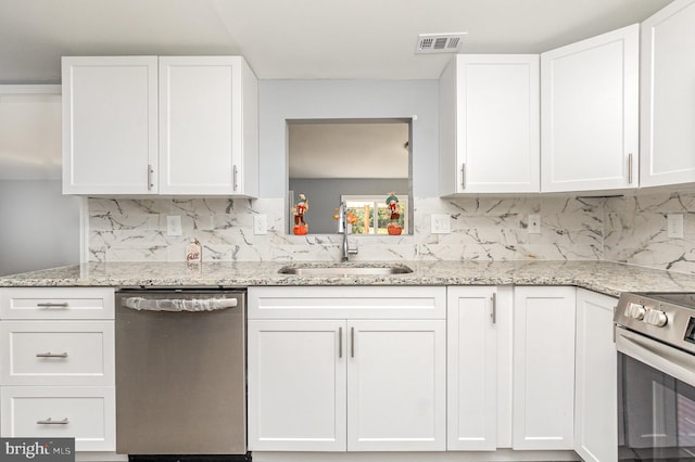 kitchen with light stone counters, white cabinets, stainless steel appliances, and sink