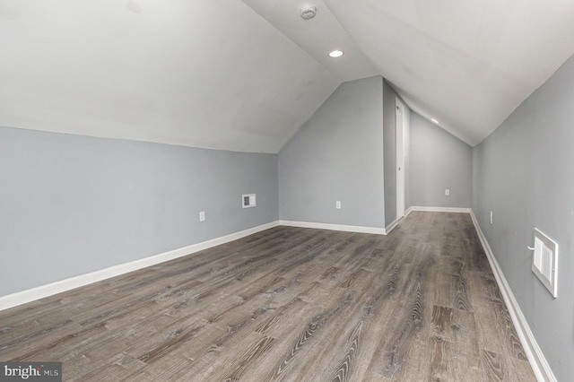 additional living space with vaulted ceiling and hardwood / wood-style flooring