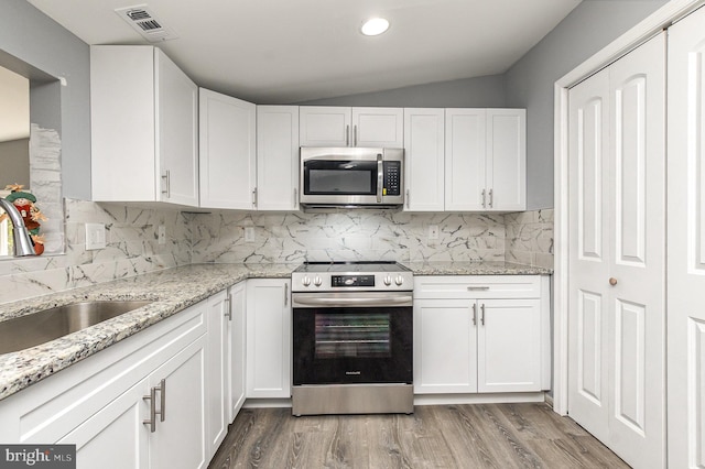 kitchen with stainless steel appliances, light hardwood / wood-style floors, sink, and white cabinetry