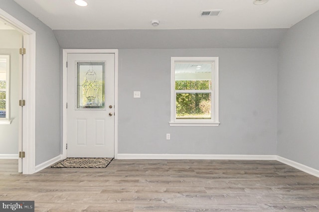 foyer featuring vaulted ceiling and light hardwood / wood-style floors