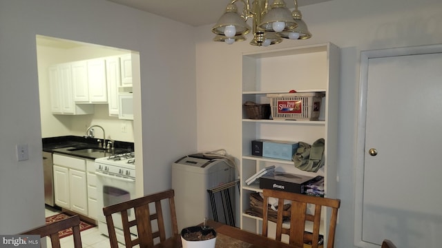 kitchen with white cabinets, light tile patterned floors, an inviting chandelier, sink, and white appliances