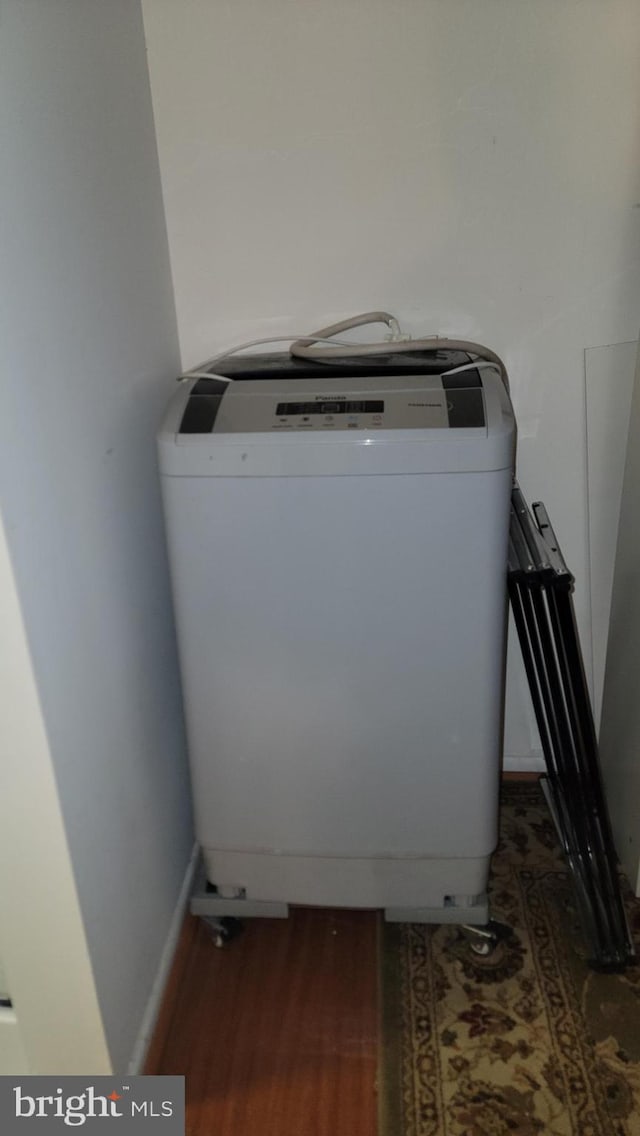 laundry area with dark hardwood / wood-style flooring