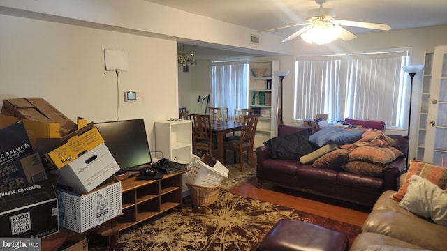 living room with hardwood / wood-style flooring and ceiling fan with notable chandelier