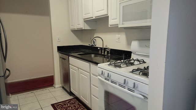 kitchen with white appliances, white cabinetry, light tile patterned floors, and sink