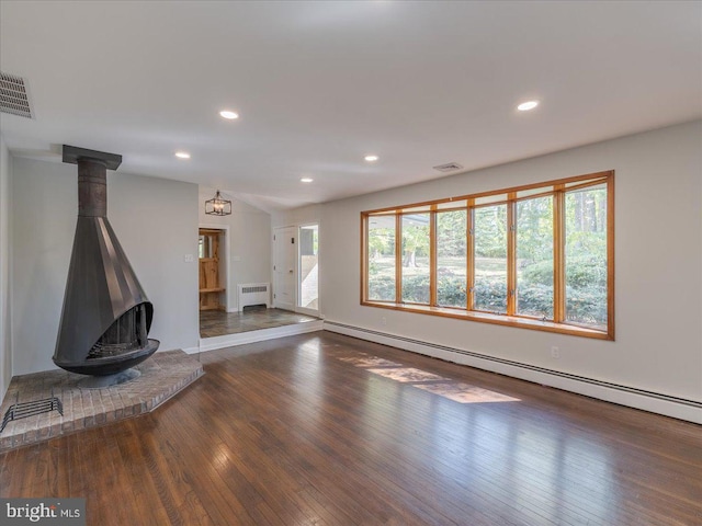 unfurnished living room featuring a wood stove, radiator heating unit, a baseboard radiator, and dark hardwood / wood-style floors