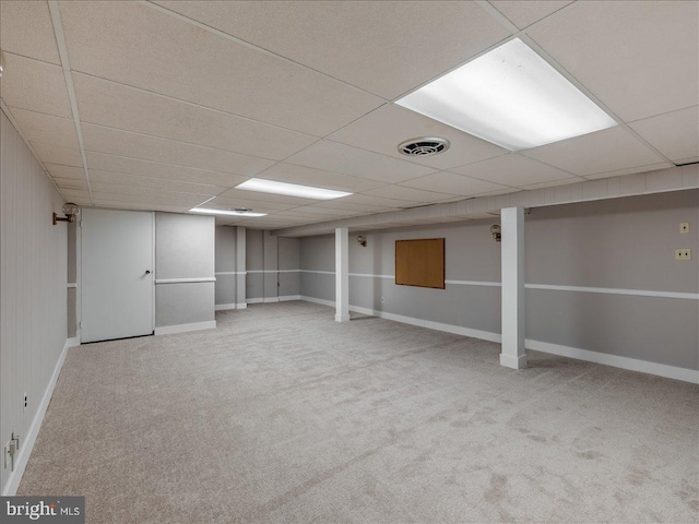 basement featuring light carpet and a paneled ceiling