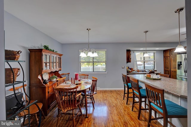 dining area featuring an inviting chandelier and light wood-type flooring