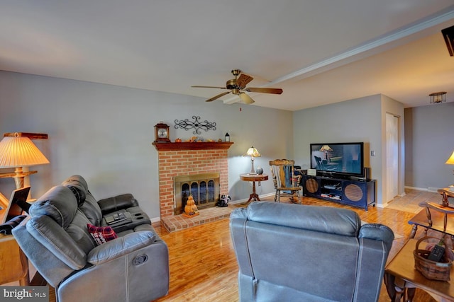 living room featuring a fireplace, ceiling fan, and wood-type flooring