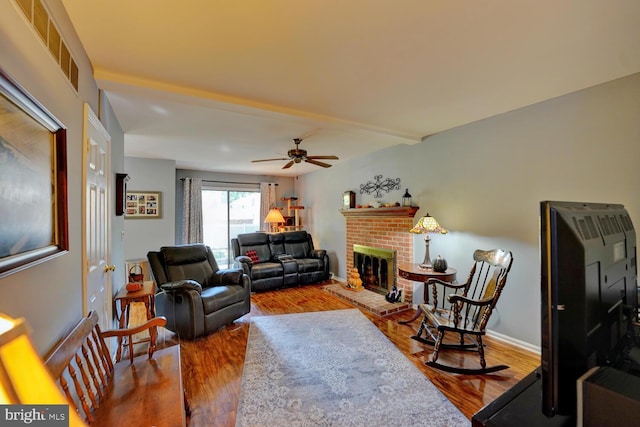 living room featuring a fireplace, hardwood / wood-style flooring, and ceiling fan