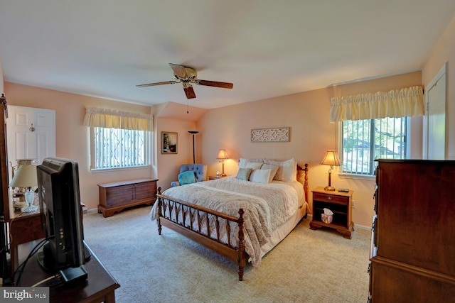 carpeted bedroom with multiple windows and ceiling fan