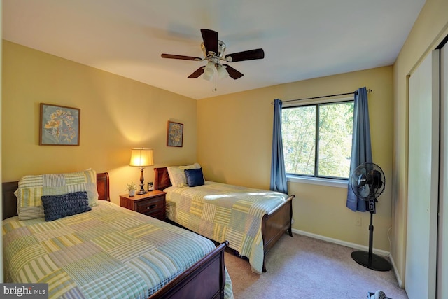 carpeted bedroom with ceiling fan and a closet